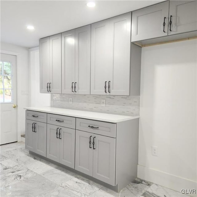 kitchen with backsplash and gray cabinetry