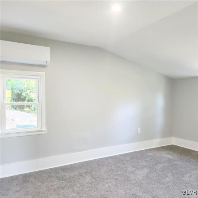 carpeted spare room with lofted ceiling and a wall unit AC