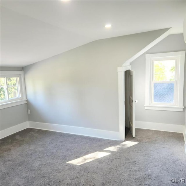 carpeted spare room with lofted ceiling and a healthy amount of sunlight