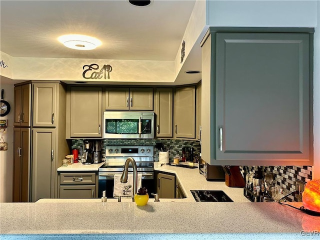 kitchen with stainless steel appliances, decorative backsplash, and gray cabinets