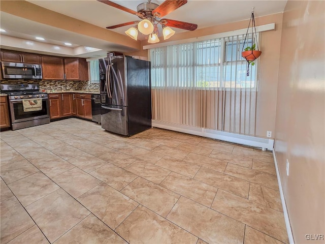 kitchen featuring ceiling fan, stainless steel appliances, backsplash, and a baseboard heating unit