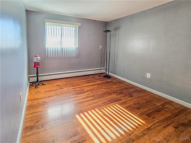 spare room with a baseboard heating unit and hardwood / wood-style flooring