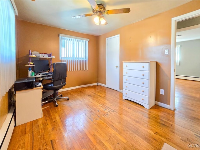 office space featuring wood-type flooring, a baseboard heating unit, and ceiling fan