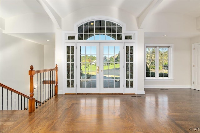 foyer entrance with french doors, lofted ceiling with beams, and dark hardwood / wood-style flooring