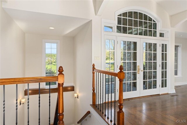 stairs with french doors and hardwood / wood-style floors