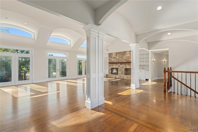 unfurnished living room with hardwood / wood-style flooring, a fireplace, a wealth of natural light, and french doors