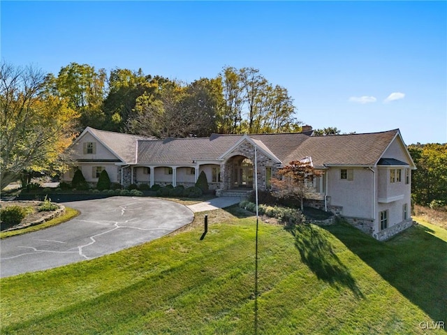 single story home with basketball hoop and a front yard