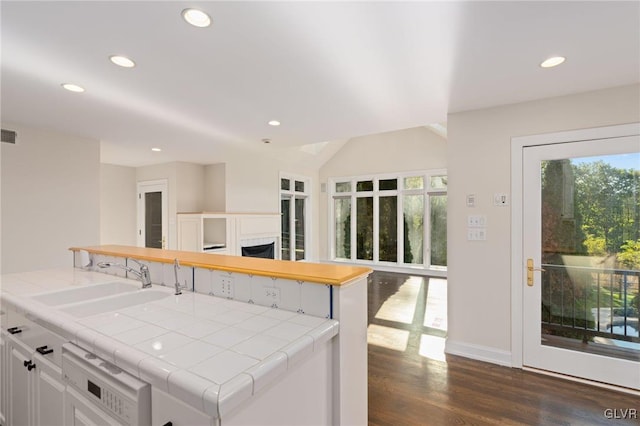 kitchen featuring white cabinets, sink, plenty of natural light, and tile counters