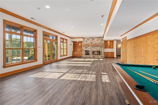 rec room with crown molding, a stone fireplace, dark hardwood / wood-style floors, and billiards