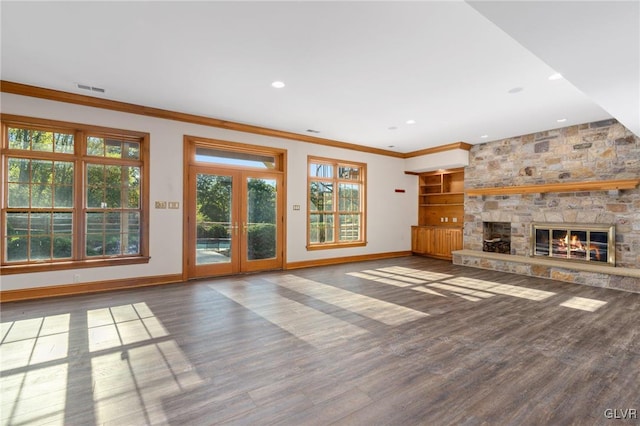 unfurnished living room featuring built in shelves, hardwood / wood-style flooring, a fireplace, and crown molding