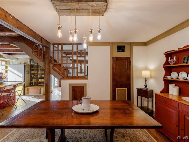 dining area with beam ceiling, hardwood / wood-style floors, and a healthy amount of sunlight