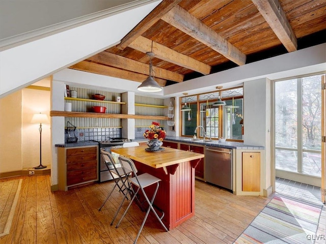 kitchen with wooden counters, a breakfast bar area, beamed ceiling, wood ceiling, and stainless steel appliances