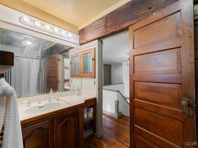 bathroom with curtained shower, vanity, and hardwood / wood-style flooring