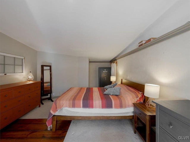 bedroom with vaulted ceiling and dark colored carpet