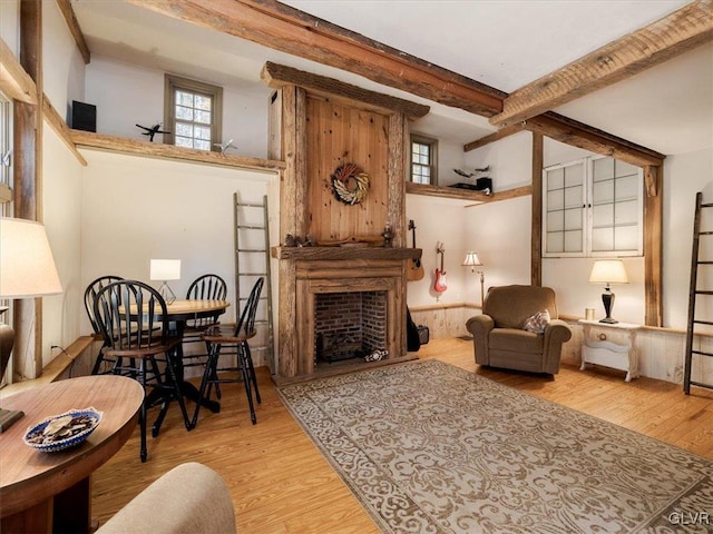 sitting room featuring beamed ceiling, a high ceiling, and light hardwood / wood-style flooring