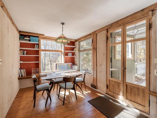 dining room with wooden walls and hardwood / wood-style floors