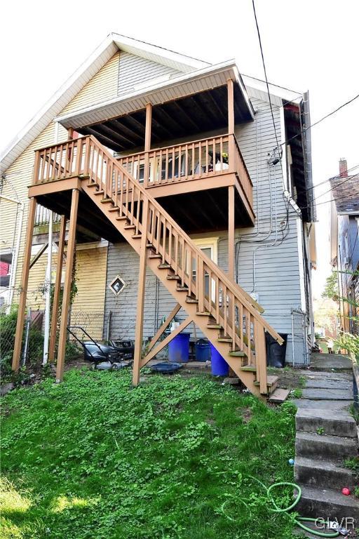 rear view of house featuring a yard and a deck