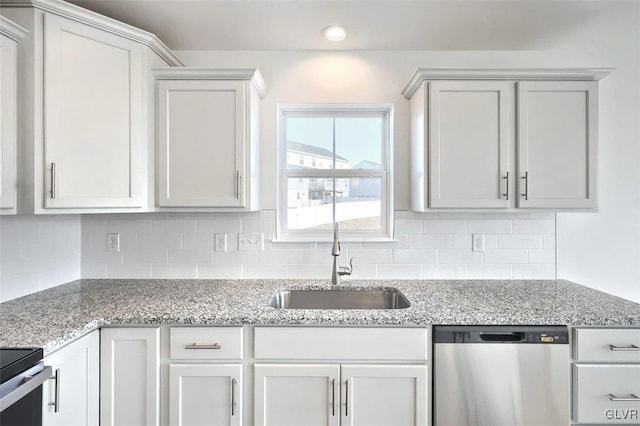 kitchen with a sink, backsplash, light stone counters, and stainless steel dishwasher