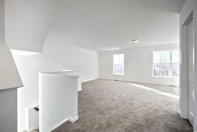 spare room with baseboards and carpet floors