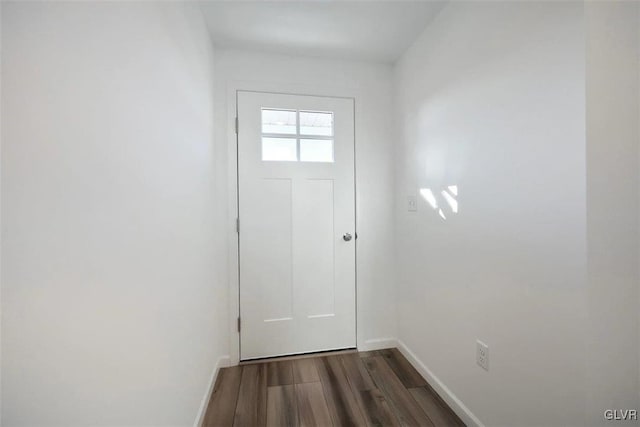 doorway with baseboards and dark wood-style flooring