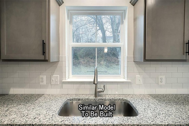 kitchen with light stone countertops, plenty of natural light, and backsplash