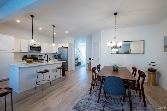 dining room featuring an inviting chandelier and light wood-type flooring