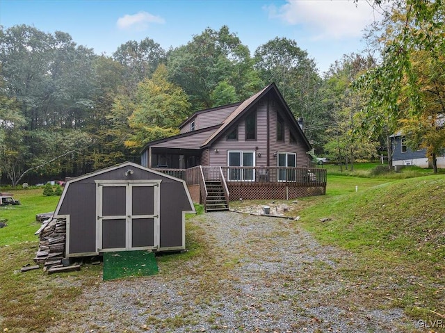 back of house with a yard, a deck, and a storage shed