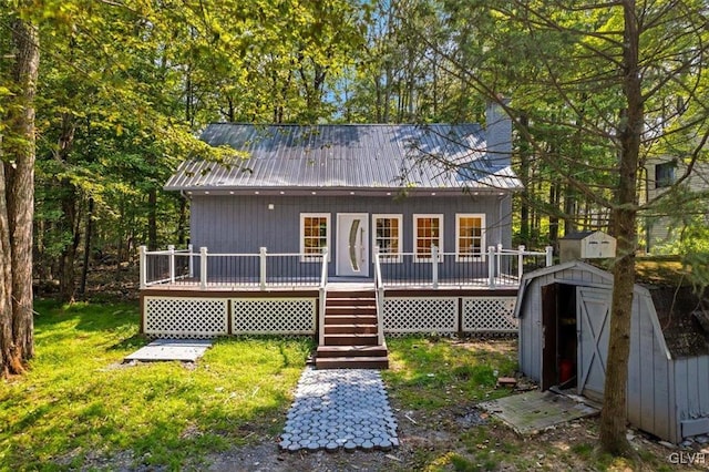 rear view of property with a shed and a wooden deck