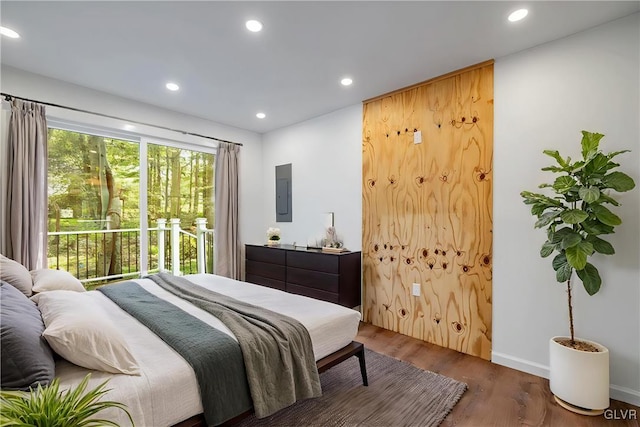 bedroom featuring electric panel and dark hardwood / wood-style flooring