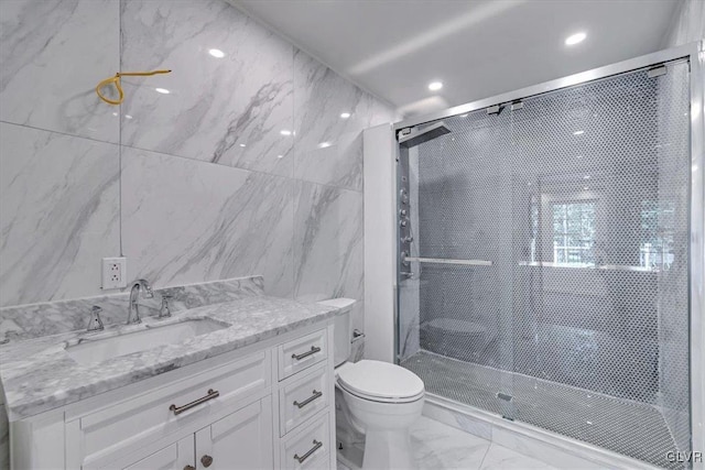 bathroom with an enclosed shower, vanity, tile walls, and toilet