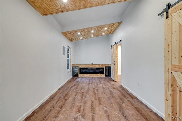 hallway featuring a barn door, wooden ceiling, lofted ceiling, and hardwood / wood-style flooring