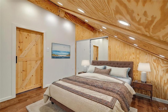 bedroom featuring wood-type flooring, a closet, and high vaulted ceiling