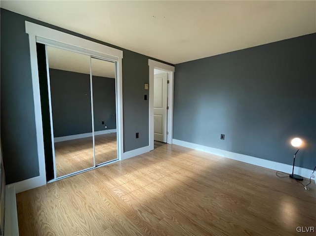 unfurnished bedroom with light hardwood / wood-style floors and a closet