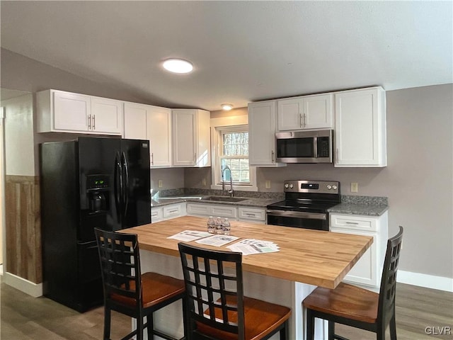 kitchen featuring a breakfast bar area, white cabinetry, sink, and stainless steel appliances