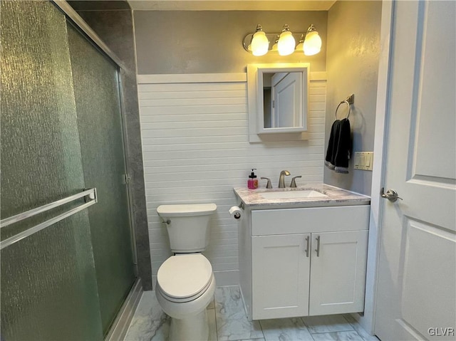 bathroom with vanity, toilet, and a shower with door