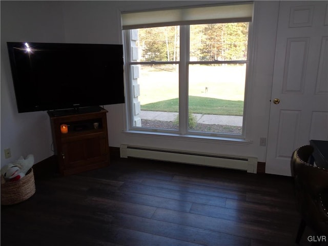 living room featuring plenty of natural light, baseboard heating, and dark hardwood / wood-style flooring