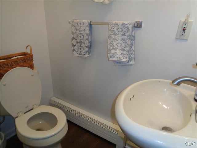 bathroom with sink, a baseboard radiator, and toilet