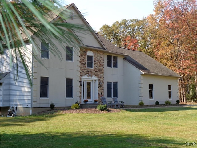 144 Dogwood Dr, Penn Forest Township, PA 18229 - view of front facade featuring a front lawn, stone siding, roof with shingles, and stucco siding
