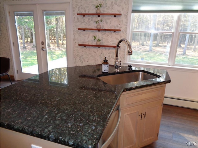 144 Dogwood Dr, Penn Forest Township, PA 18229 - kitchen with a sink, baseboard heating, stainless steel dishwasher, dark stone countertops, and an island with sink