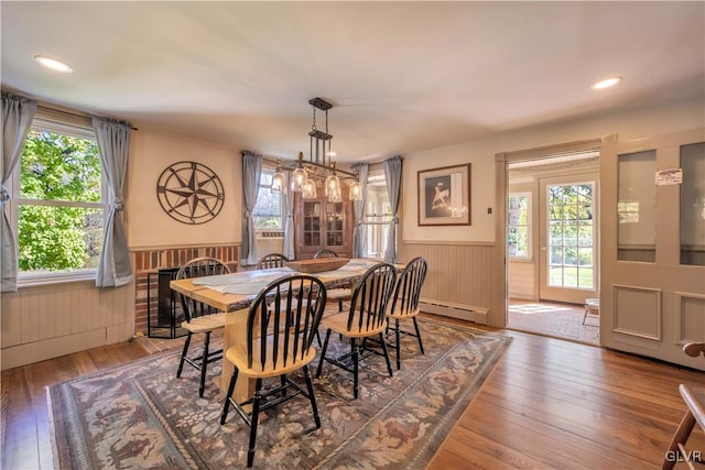 dining space with a brick fireplace, hardwood / wood-style floors, and a wealth of natural light