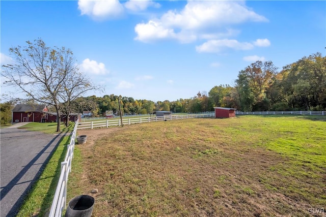 view of yard with a rural view and an outdoor structure