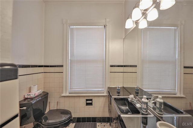 bathroom featuring toilet, tile walls, and vanity