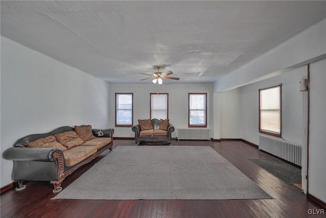 living room with a textured ceiling, ceiling fan, radiator, and dark hardwood / wood-style flooring