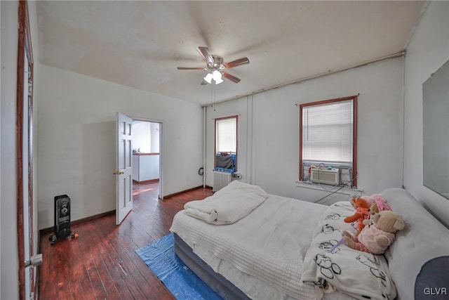 bedroom with cooling unit, ceiling fan, dark wood-type flooring, and radiator heating unit