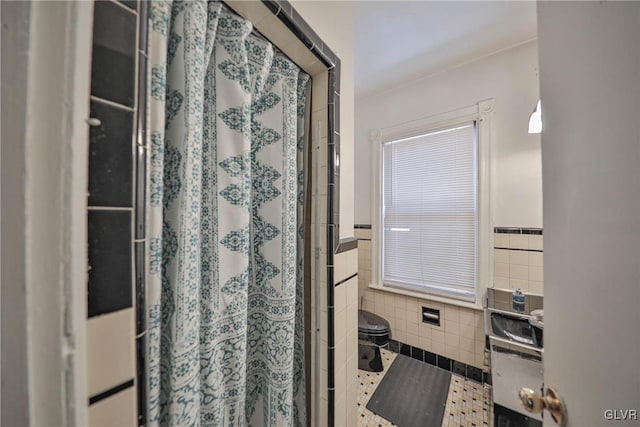 bathroom featuring tile walls, toilet, and a shower with shower curtain