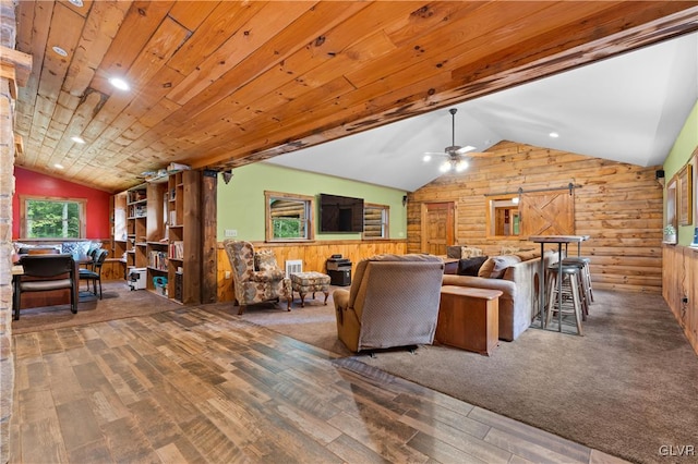 living room featuring wood-type flooring, lofted ceiling, and a barn door