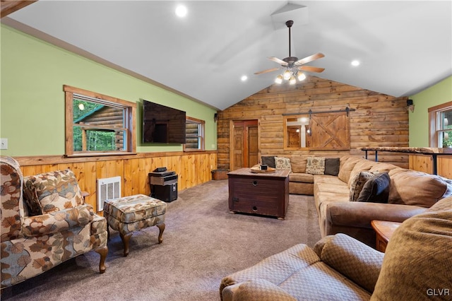 living room featuring carpet floors, vaulted ceiling, wooden walls, and ceiling fan