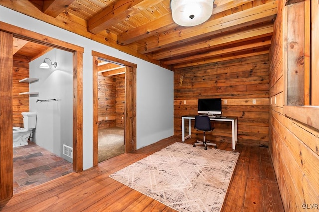 unfurnished office with wood walls, beamed ceiling, wood ceiling, and dark hardwood / wood-style flooring