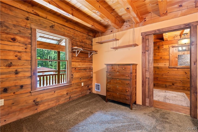 interior space featuring beamed ceiling, wooden walls, carpet flooring, and wooden ceiling