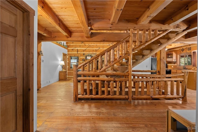 stairway featuring wood ceiling, beam ceiling, and hardwood / wood-style floors